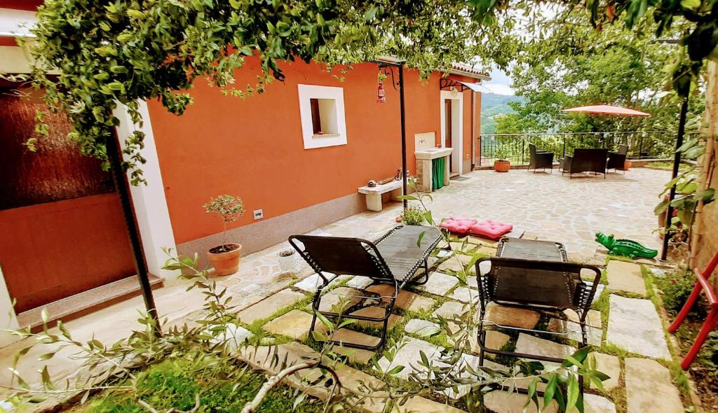 eine Terrasse mit 2 Stühlen und ein Haus in der Unterkunft Provvidenza in Motovun