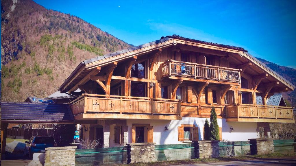 a large wooden house with a balcony on top of it at Chalet Clos Moccand in Samoëns