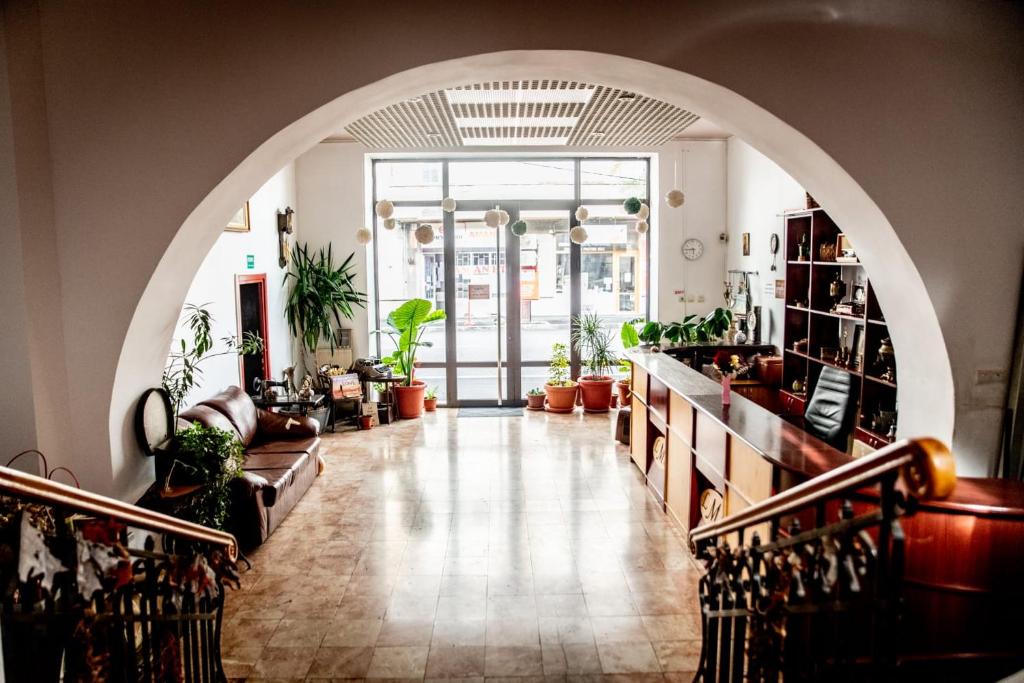 - un couloir avec une arche dans une pièce ornée de plantes dans l'établissement Pensiunea Lms, à Brăila