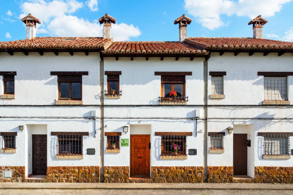 Casa blanca con ventanas y techo rojo en Casa El Caminero, en Rubielos de Mora