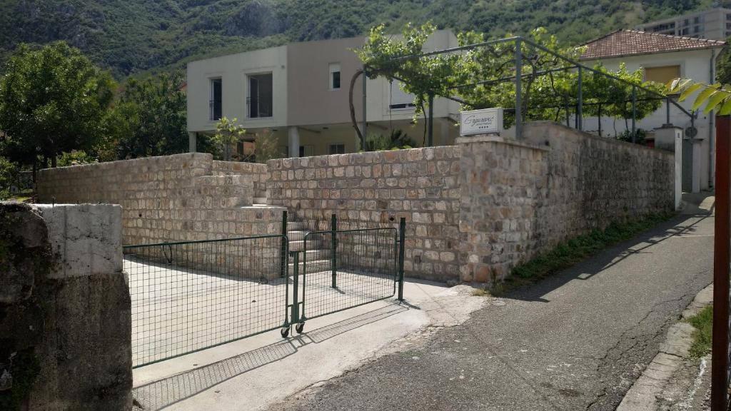 a brick retaining wall with a gate on a street at Apartments Grgurević in Kotor