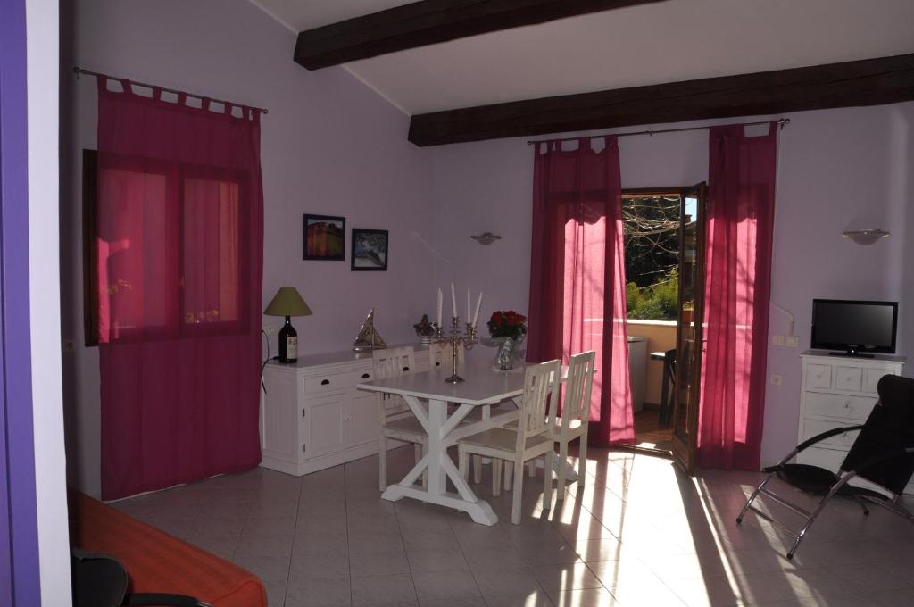 ein Esszimmer mit rosa Vorhängen und einem Tisch in der Unterkunft Villa Petra in Sainte-Maxime