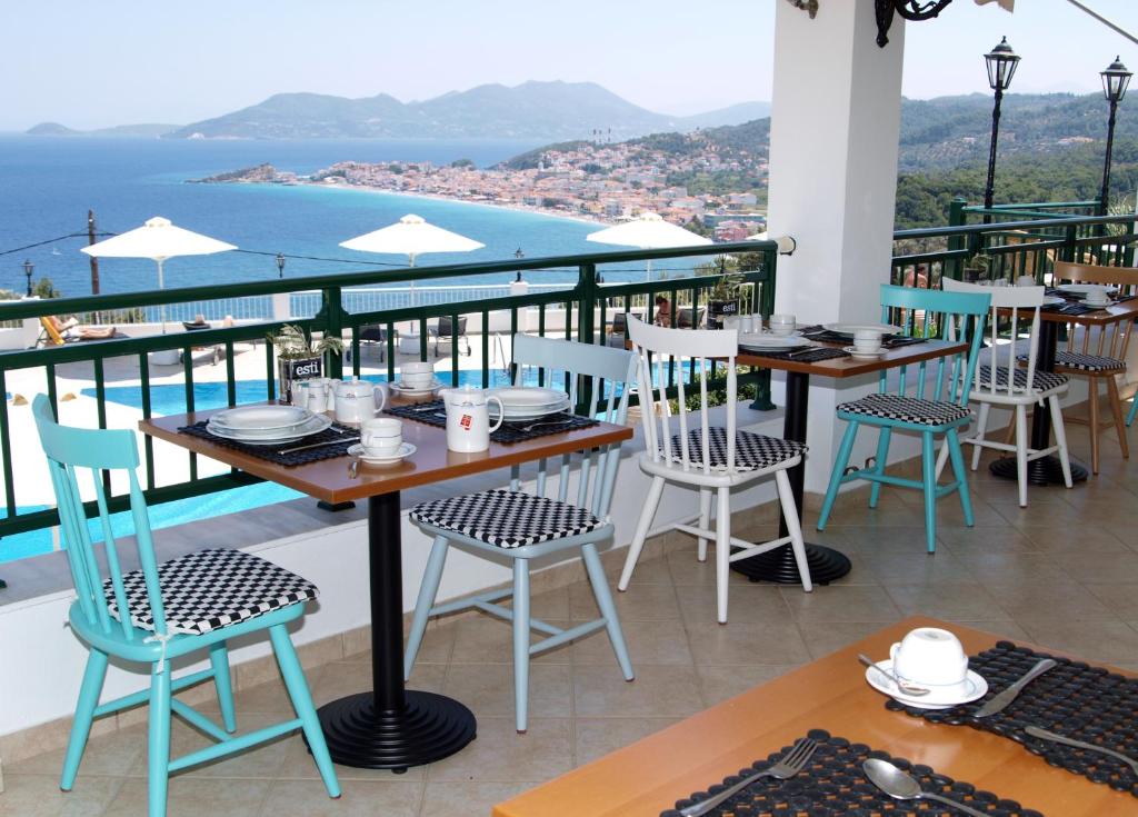a table and chairs on a balcony with a view at Kalidon Panorama Hotel in Kokkari