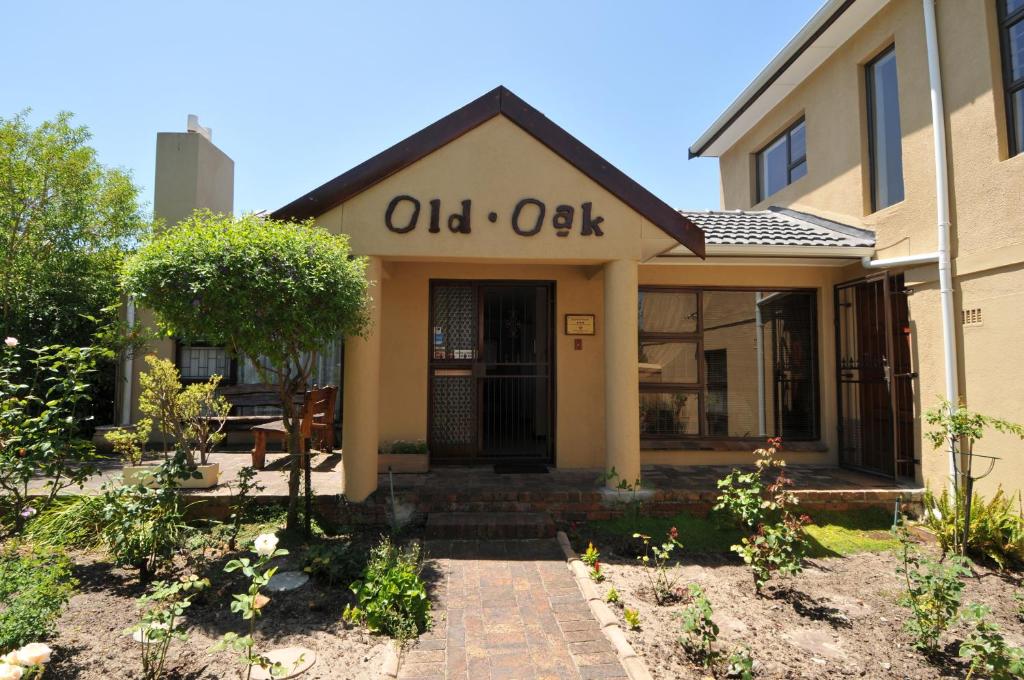 an old oak house with a sign on the door at Old Oak Guest House in Bellville