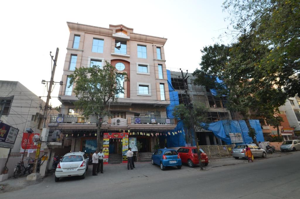 a building on the side of a street with parked cars at Hotel Annapoorna Residency in Hyderabad