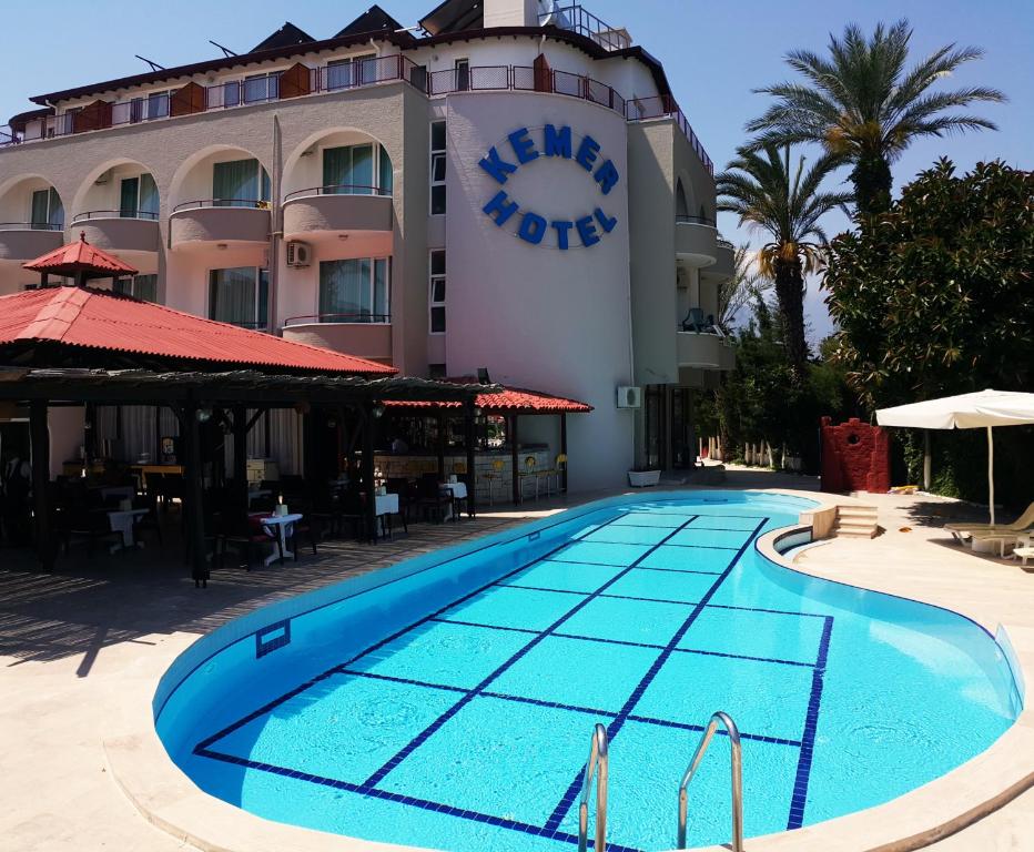 un hôtel avec une piscine en face d'un bâtiment dans l'établissement Kemer Hotel, à Kemer