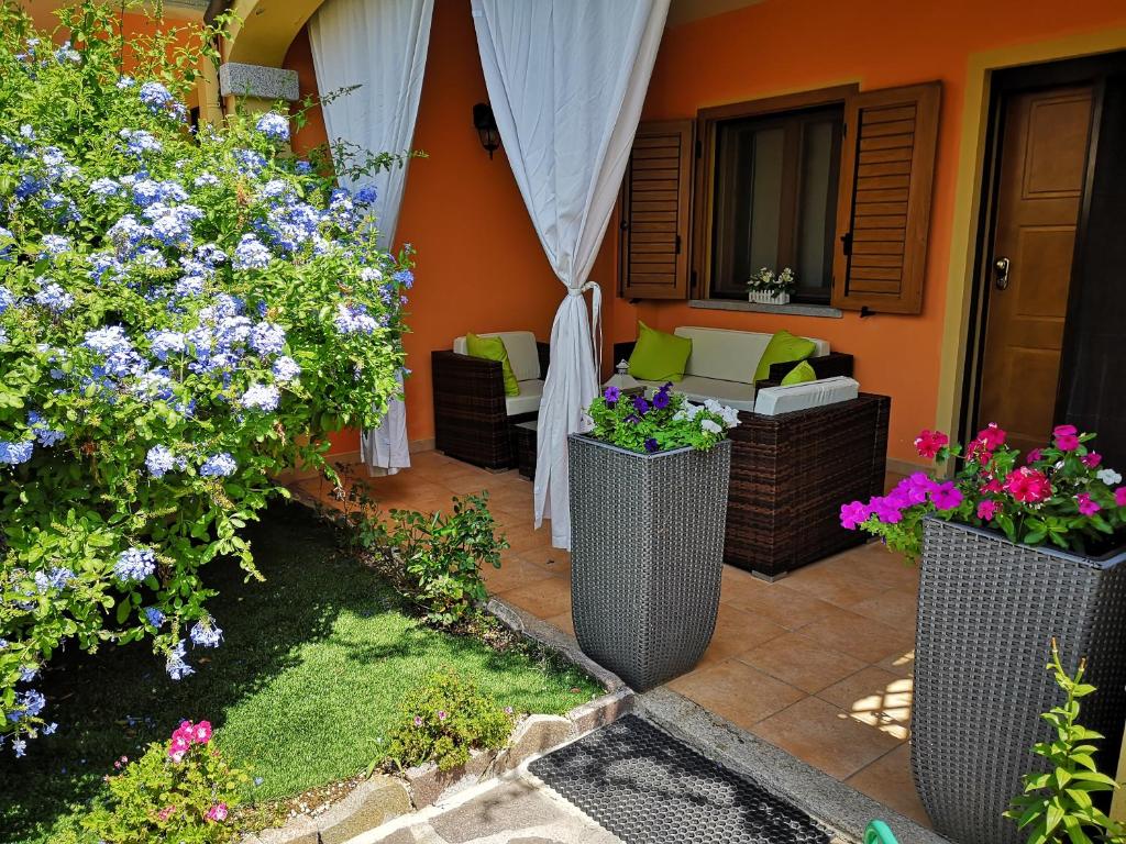 un patio con flores, mesa y sillas en Casa con Giardino, en Olbia