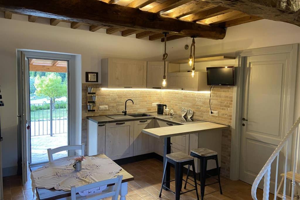 cocina con encimera y mesa con sillas en La Casetta di nonnaNà - Casa vacanze, en Terni