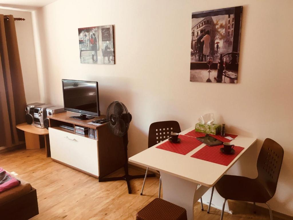 Zimmer mit einem Tisch und einem Schreibtisch mit einem TV in der Unterkunft Apartmán Na Pohodu 25 in Lipno nad Vltavou