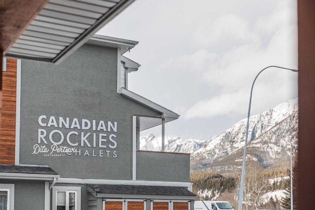 una señal en el lateral de un edificio con montañas en Canadian Rockies Chalets en Canmore