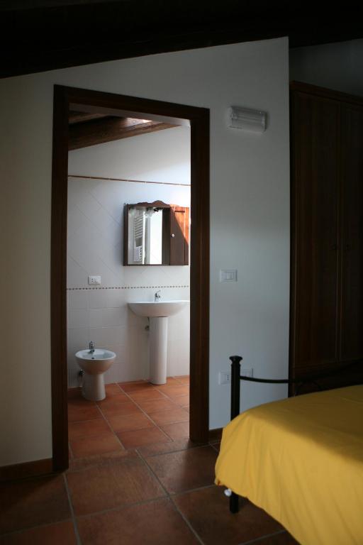 sypialnia z łazienką z umywalką i lustrem w obiekcie Agriturismo La Rosta w mieście Cervignano del Friuli