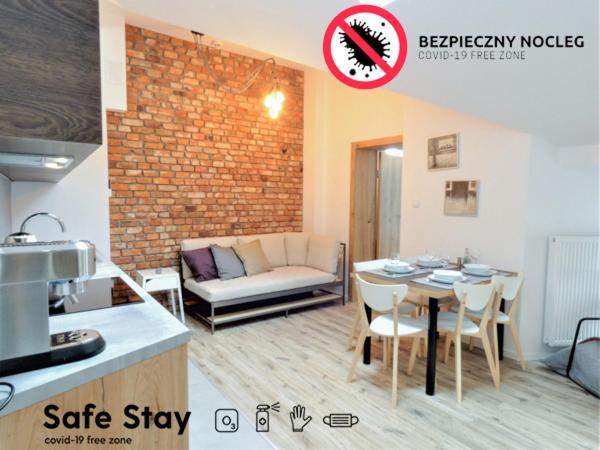 una cucina e un soggiorno con tavolo e divano di Way2Stay Bosacka a Cracovia