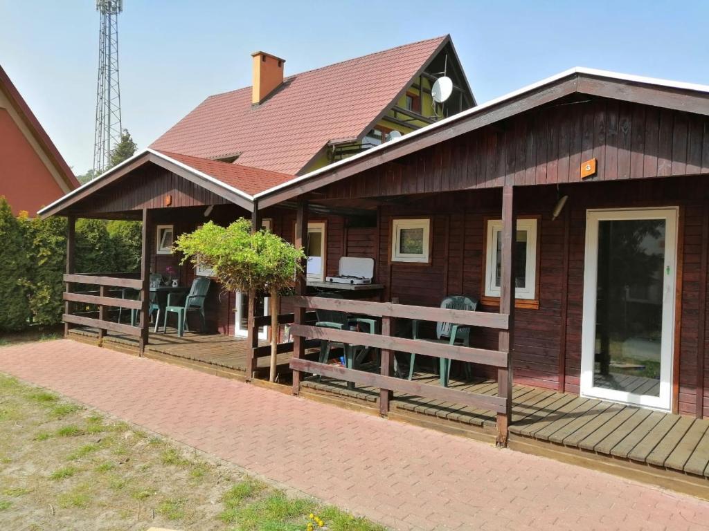drewniany dom z werandą i patio w obiekcie Domki Letniskowe Ster w mieście Międzyzdroje