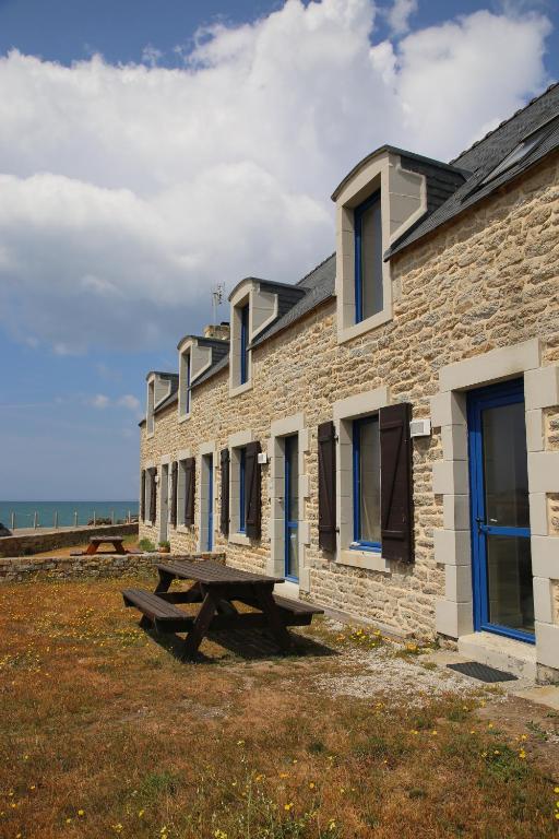 un edificio de piedra con una mesa de picnic delante de él en Ker Karreg (La Maison du Rocher), en Penmarch