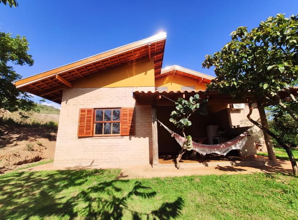 una pequeña casa con una hamaca delante en Céu da Canastra, en Delfinópolis