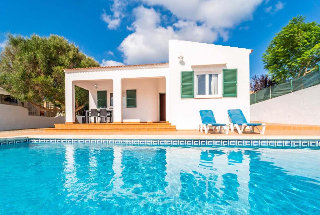 a villa with a swimming pool in front of a house at Villa Patri in Cala en Porter