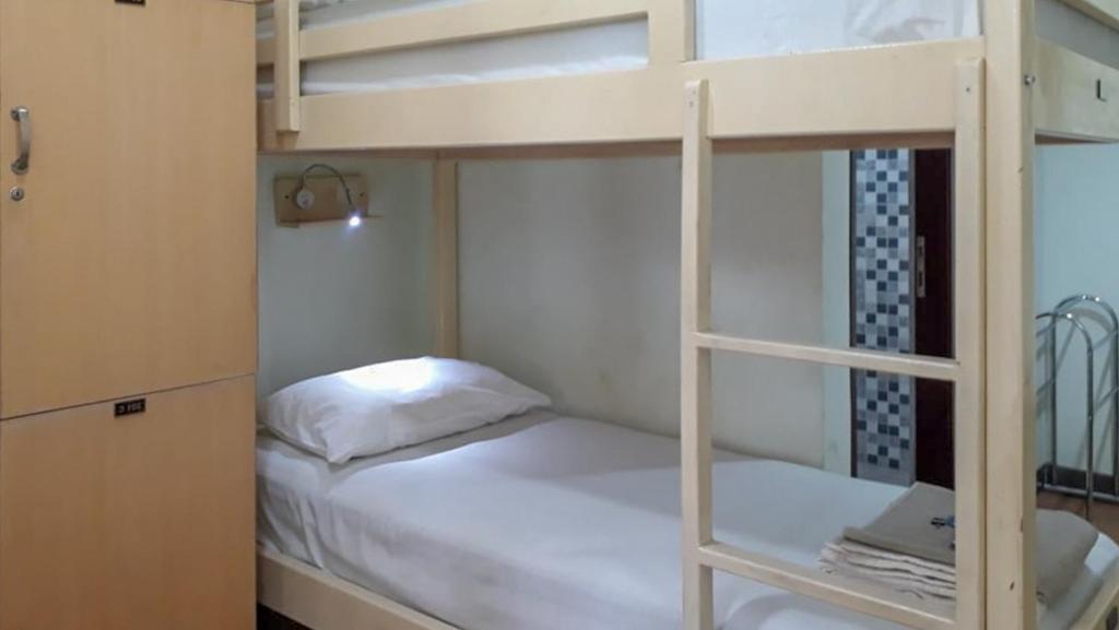 1 dormitorio con litera y cama blanca en RedDoorz Hostel @ Manado Green Hostel en Manado