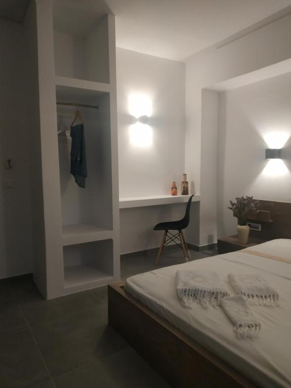 a bedroom with a bed and a desk and a chair at ENALION-TINOS in Tinos Town