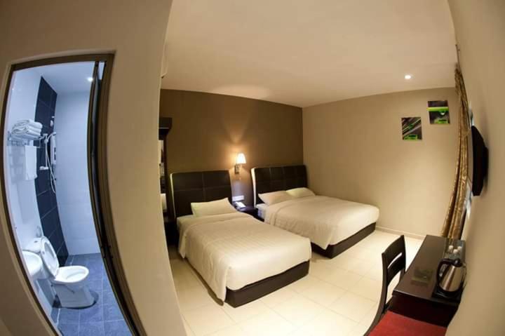 Postel nebo postele na pokoji v ubytování Ayer Hitam Hotel