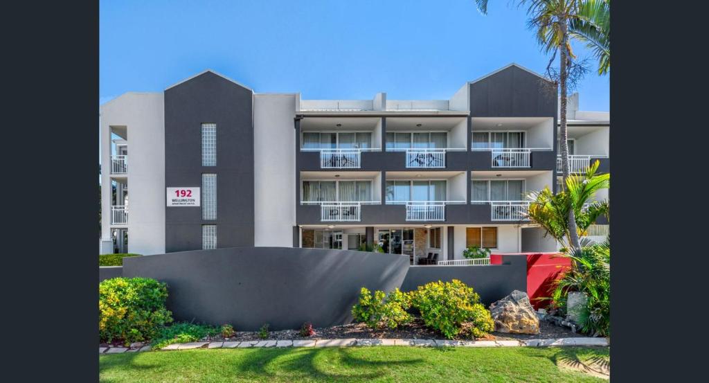 an exterior view of a building with a yard at The Wellington Apartment Hotel in Brisbane