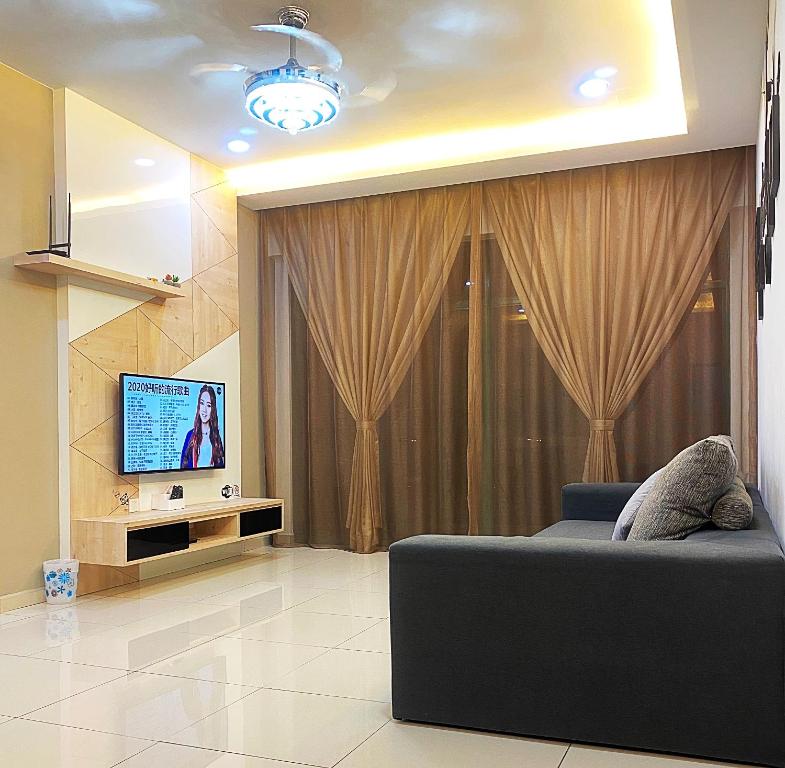 sala de estar con sofá y TV en Amadel Residence 爱媄德民宿 13, en Melaka