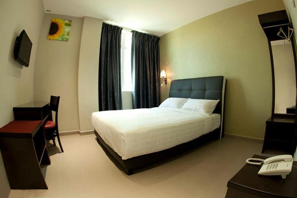 Postel nebo postele na pokoji v ubytování Ayer Hitam Hotel