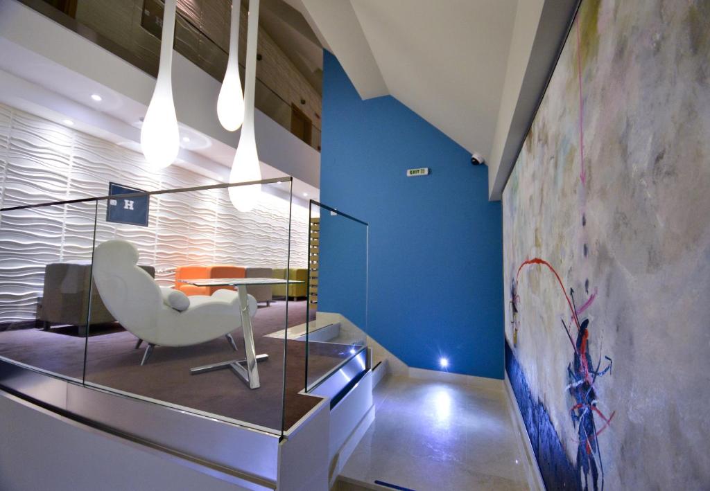 a lobby with a white chair and a table at ArtLoft Garni Hotel in Niš