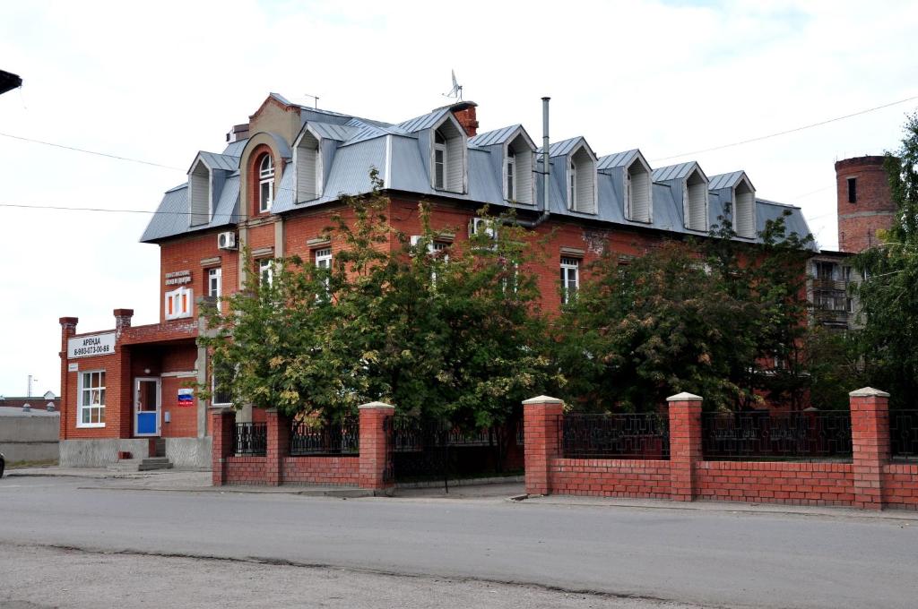 a red brick building with a metal roof at 22-HOTEL in Barnaul