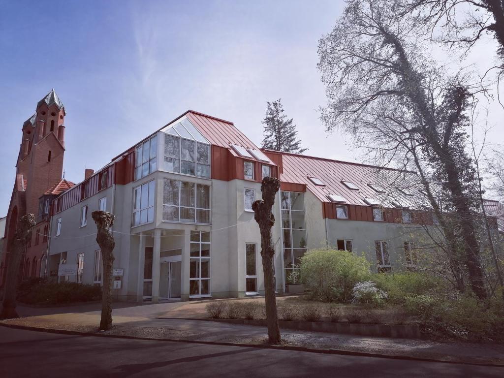 un edificio con una torre de reloj delante de él en Akzent Parkhotel Trebbin, en Trebbin