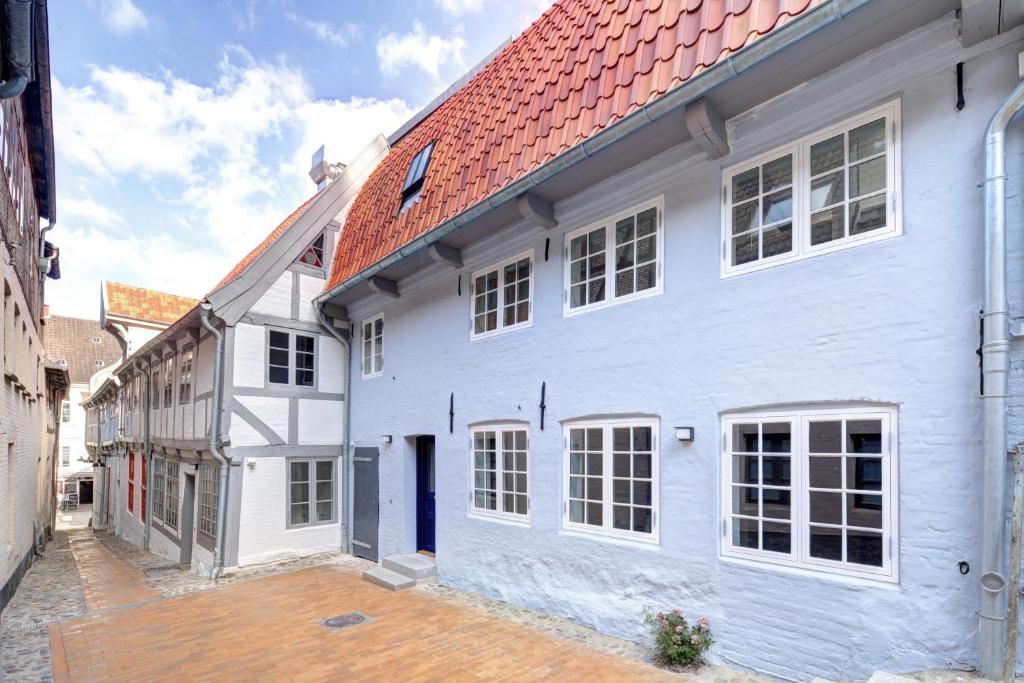 une maison blanche avec un toit rouge dans l'établissement Ferienhaus Grosse 73, Flensburg, à Flensbourg