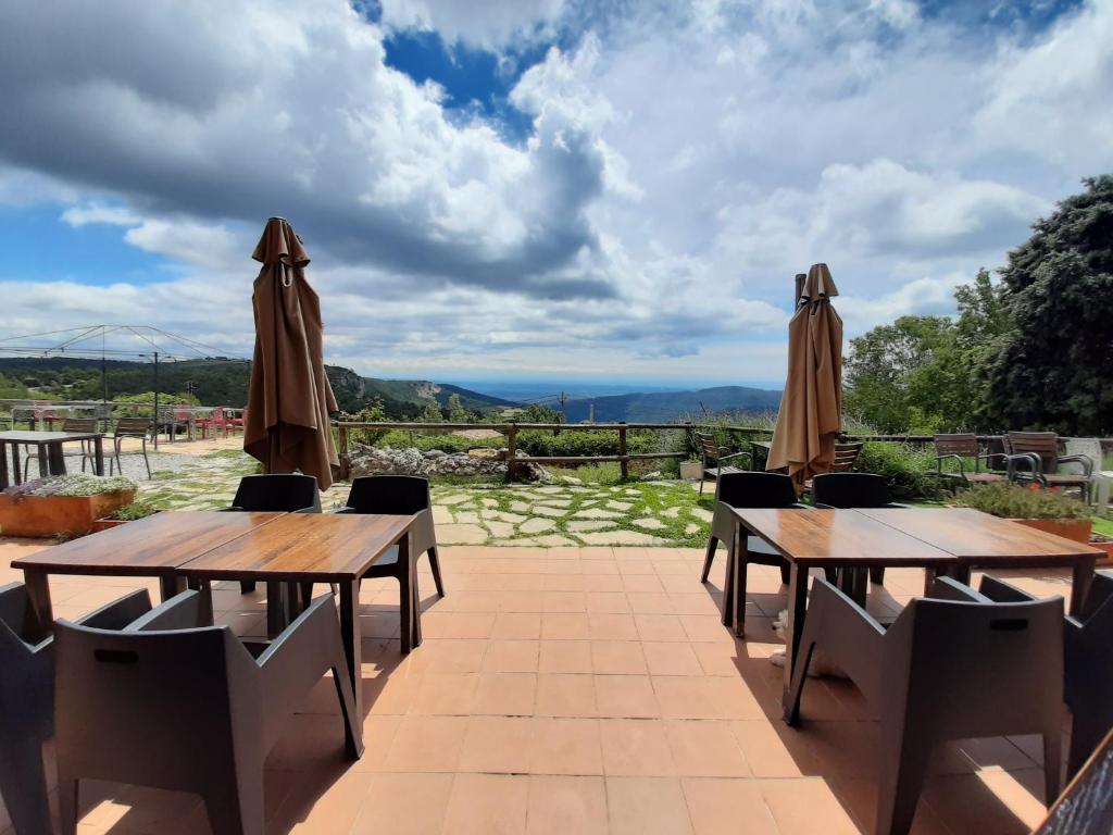 - deux tables en bois et des parasols sur une terrasse dans l'établissement Hotel Rural Cor De Prades, à Sidi Bouzid