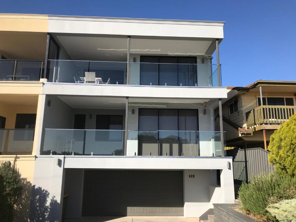 uma grande casa branca com muitas janelas em The Lighthouse - Beachfront Accommodation em Port Hughes