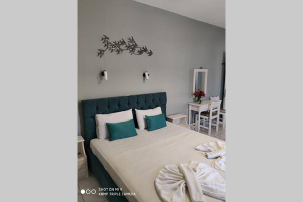 a bedroom with a large bed with blue pillows at Iason studio 2 in Patitiri