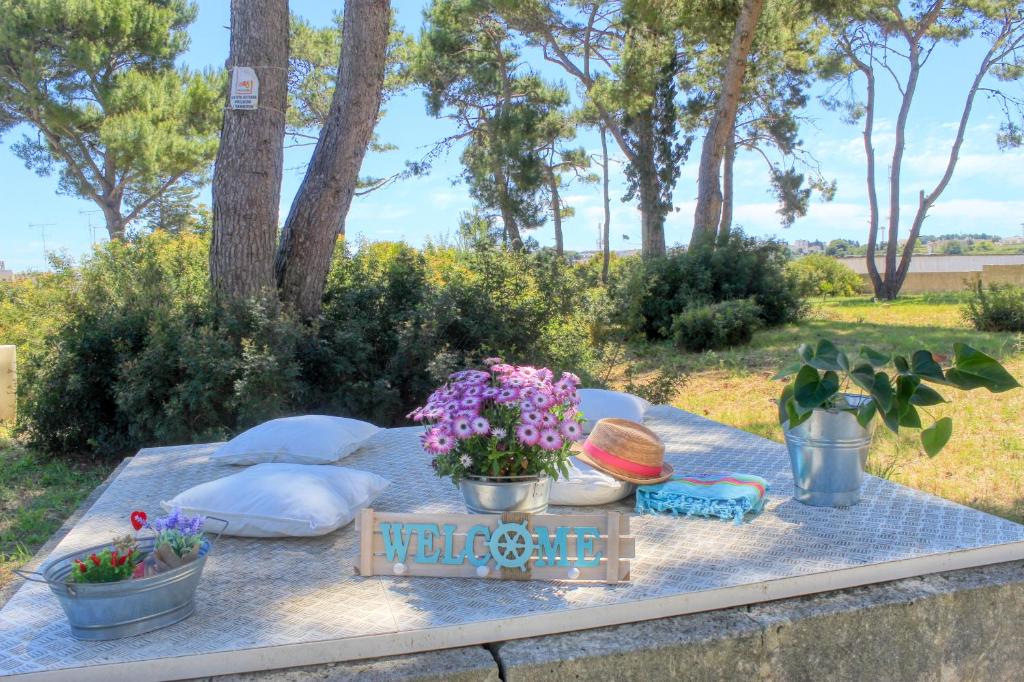 een picknicktafel met bloemen en een welkomstgeschenk bij MARIMAR - Apartments OTRANTO in Otranto