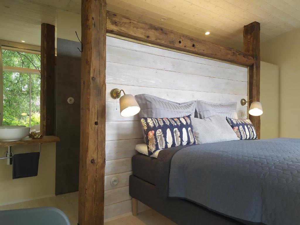 1 dormitorio con 1 cama con cabecero de madera en Penzion Na Hostici en Číměř