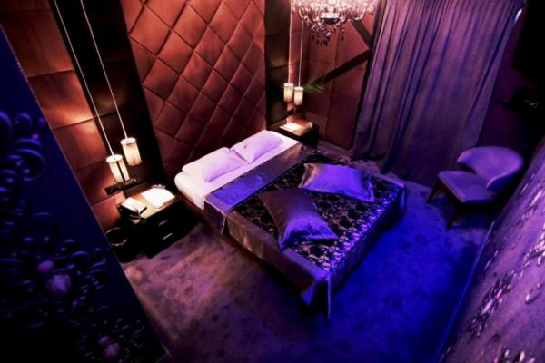 una camera da letto con una camera viola con letti e sedie di THE CRYSTAL BLUE XAIDARI HOTEL a Pireo