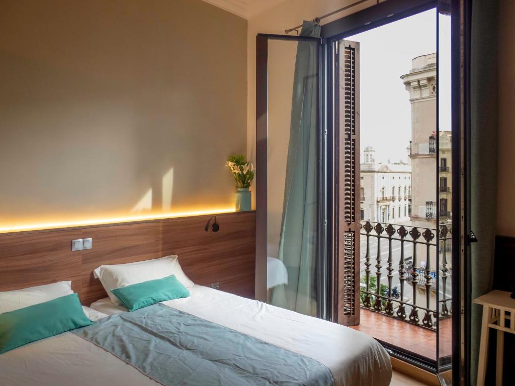 a bedroom with a bed and a large window at Pension Ciudadela in Barcelona