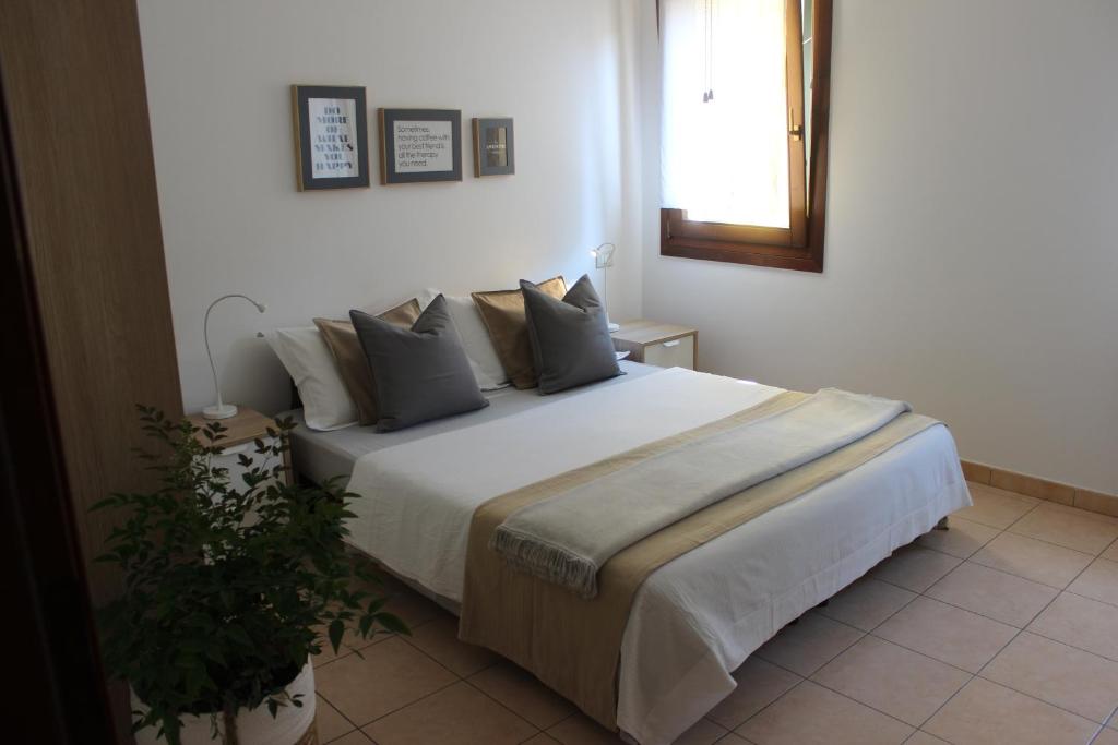 ein Schlafzimmer mit einem großen weißen Bett mit Kissen in der Unterkunft Casa Vacanze Giorgetta 2-3 piano in Chioggia