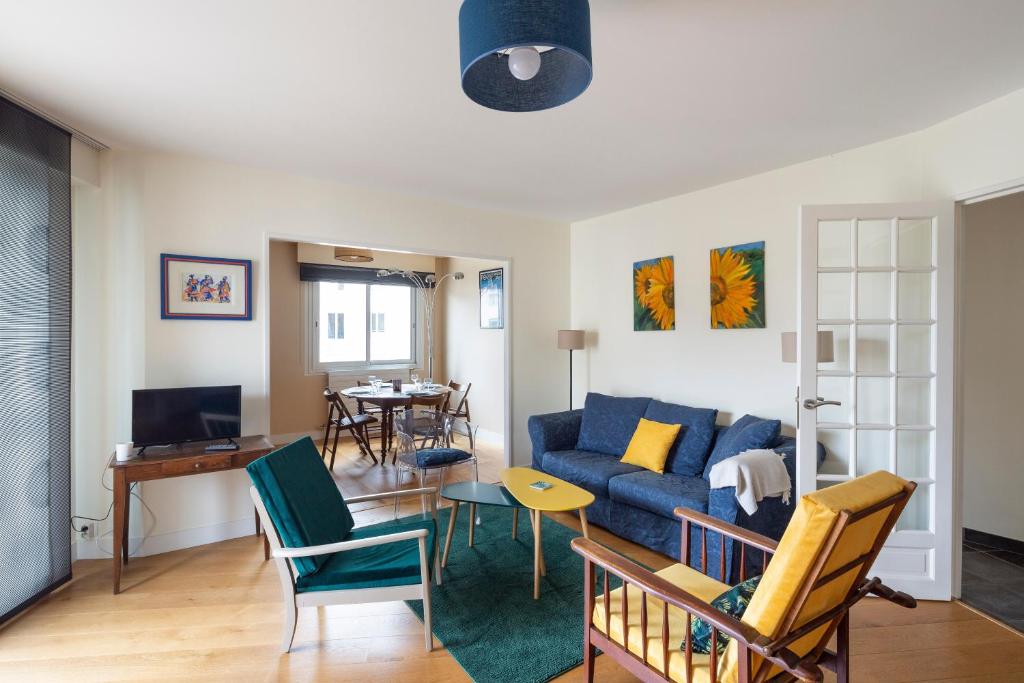 sala de estar con sofá azul y sillas en Le Singulier - 2 chambres et parking en Nantes