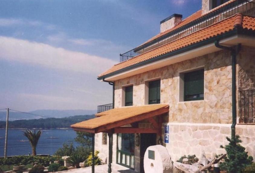 a large building with a view of the water at Hotel Rústico Punta Uia in Uhía