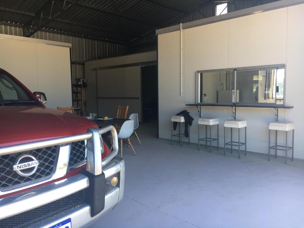 einem LKW, der in einer Garage mit einem Tisch und Stühlen geparkt ist in der Unterkunft Something Different - Shedstay in Donnybrook