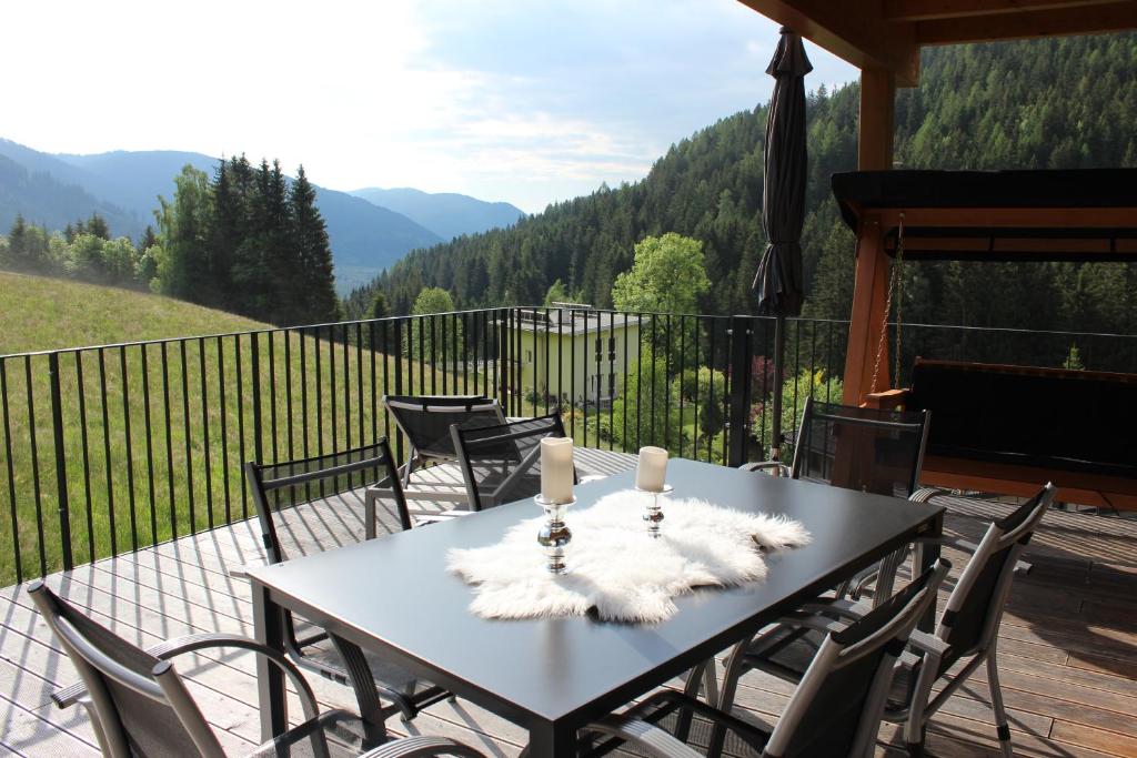 a table on a deck with a view of mountains at Penthouse Skyview im Natur-Erlebnispark Bad Kleinkirchheim in Patergassen