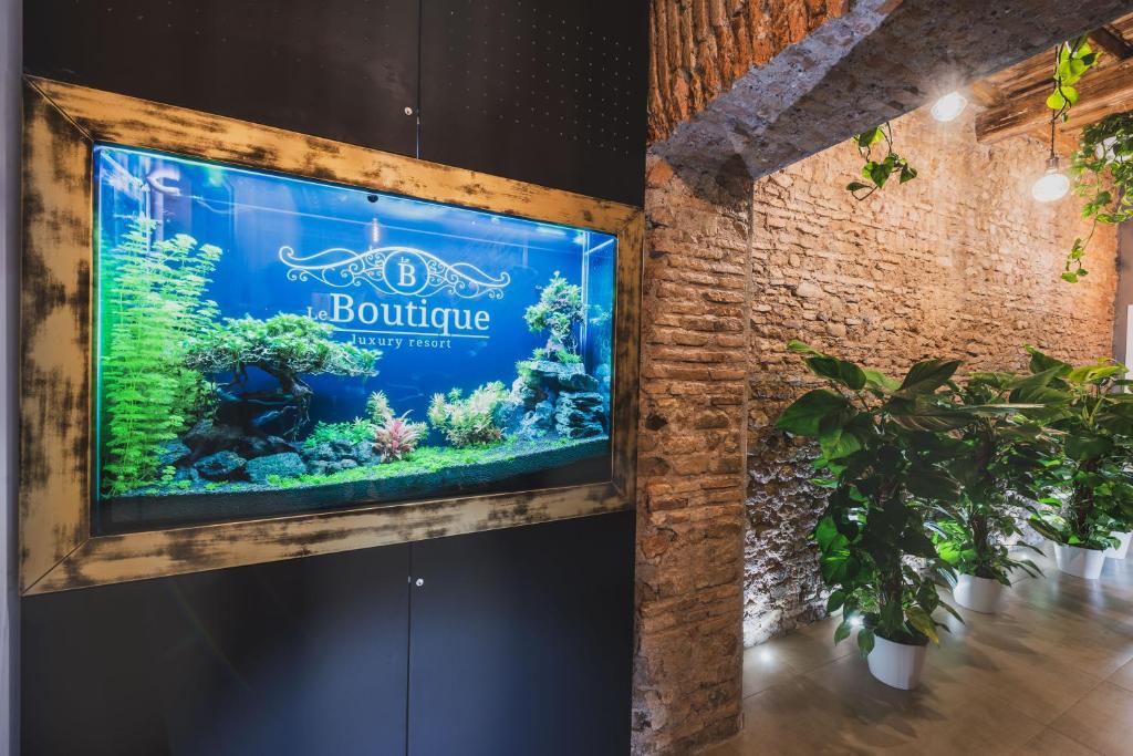 a large aquarium in a room with a brick wall at Le Boutique Luxury Rooms in Fiumicino