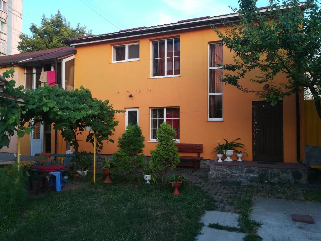 an orange house with a bench in the yard at Апельсин in Myrhorod