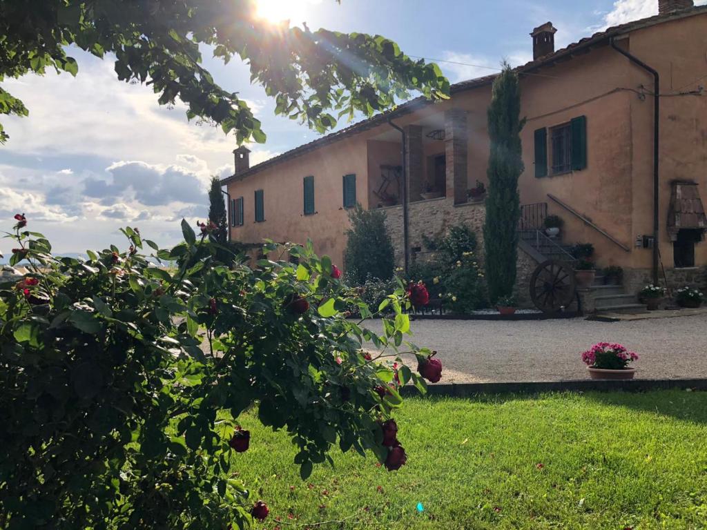 a building with the sun shining on a yard at Casolare Marconi in Panicale