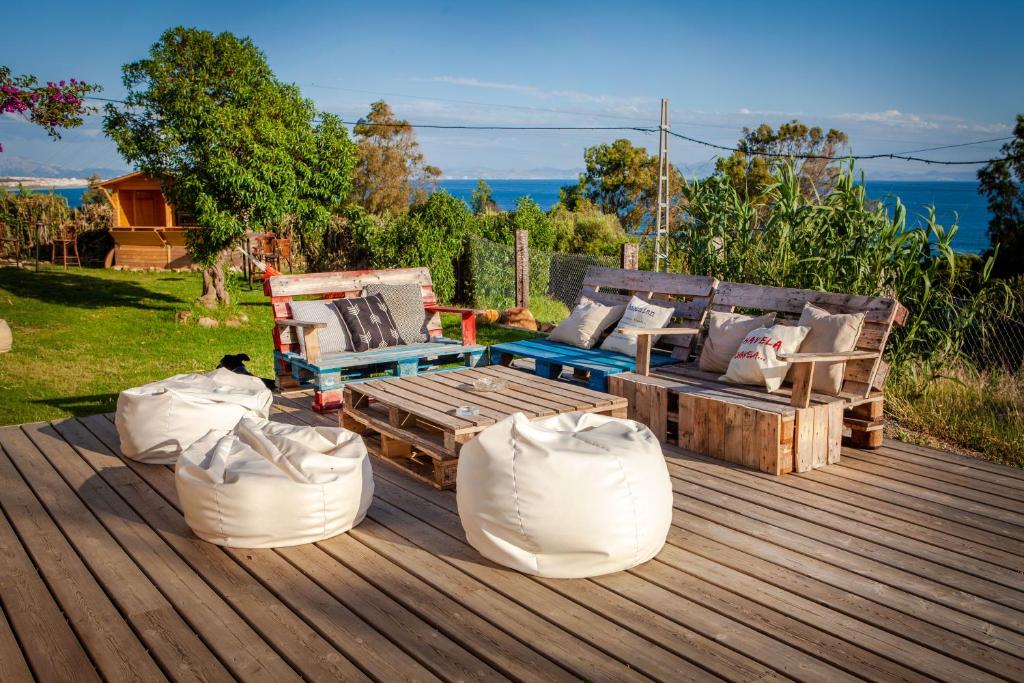 a wooden deck with a couch and two chairs on it at Wild House Tarifa in Tarifa
