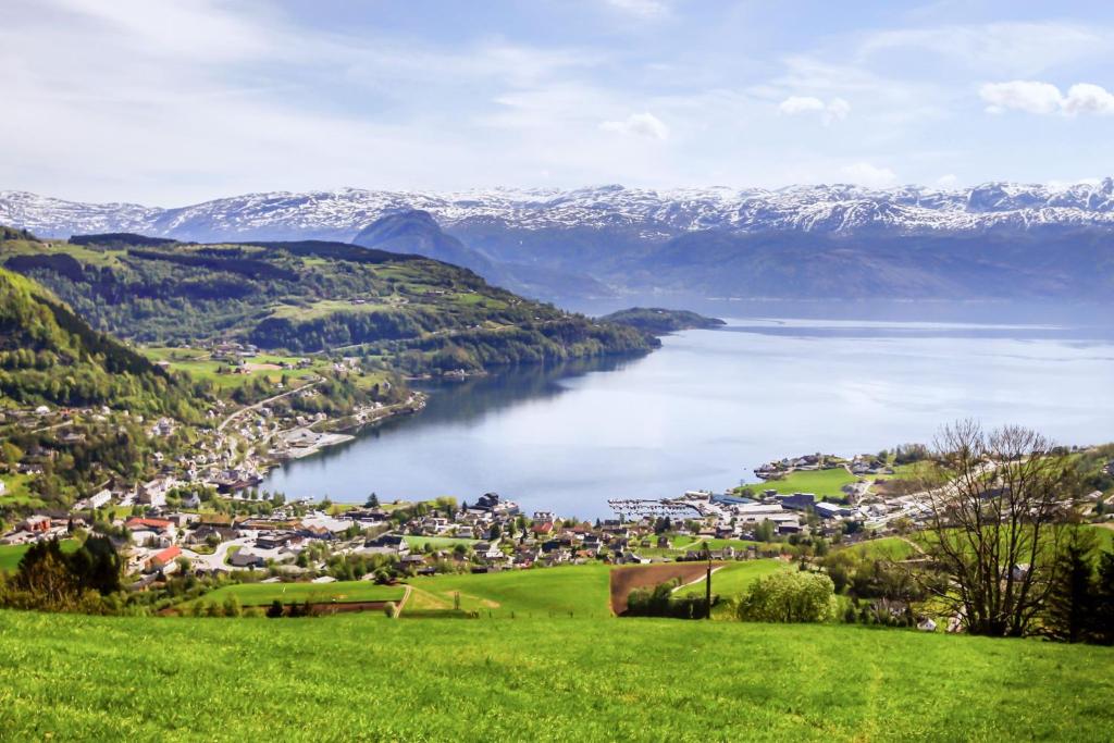 a view of a town with a lake and mountains at Hardangerfjord Hotel in Øystese