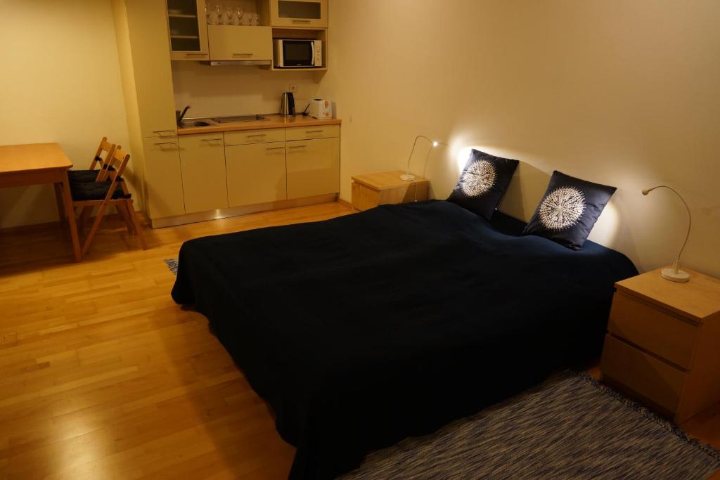 een slaapkamer met een zwart bed en een keuken bij Harrachov Apartmán 206 in Harrachov