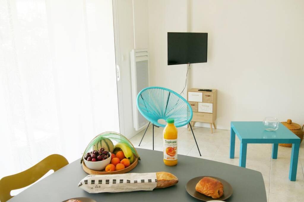 una mesa con un bol de fruta y un ventilador en Studio situé dans le centre de Saint Philibert en Saint-Philibert