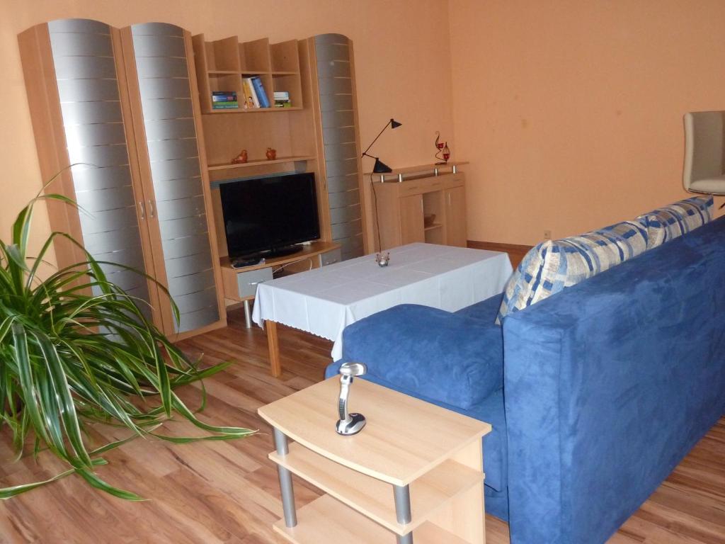 a living room with a blue couch and a tv at Ferienwohnung Am Deich in Bleckede